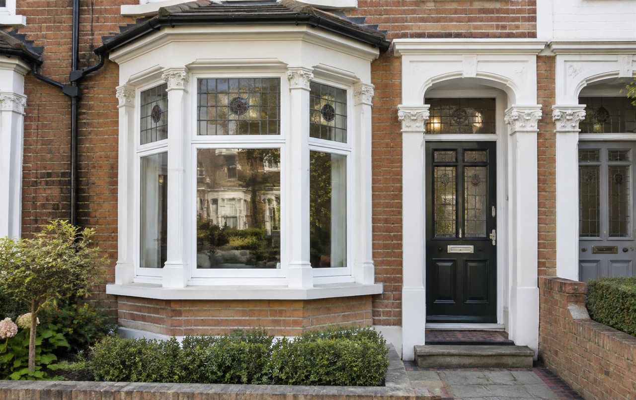 Curved bay window on a Victorian bay-fronted home with leaded top-lights and painted stone cills